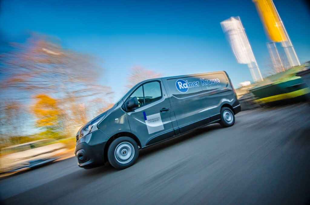 Transporter vor Fahnen von einem Trockenbaubetrieb